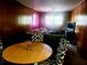 View of the living room with wood paneling, ceiling fan, stylish chairs, and comfortable seating area at 1723 Fort Valley Sw Dr, Atlanta, GA 30311