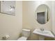 Cozy half bathroom with pedestal sink and a round mirror at 426 Mulberry Se Row, Atlanta, GA 30354