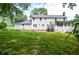 Expansive backyard with lush greenery and a white home featuring a back patio at 4714 Marc Sw Ct, Lilburn, GA 30047