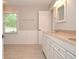 Bathroom featuring double sinks, granite countertops, white cabinets, and large window at 4714 Marc Sw Ct, Lilburn, GA 30047