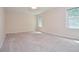 A simple bedroom featuring two windows, cream walls, and beige carpeting at 4714 Marc Sw Ct, Lilburn, GA 30047