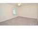 A simple bedroom featuring one window, cream walls, and beige carpeting at 4714 Marc Sw Ct, Lilburn, GA 30047