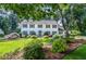 Charming two-story home showcasing a beautifully landscaped front yard with lush greenery and vibrant flowers at 4714 Marc Sw Ct, Lilburn, GA 30047