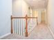 Light-filled hallway with neutral walls, plush carpeting, and classic white railing on the staircase at 4714 Marc Sw Ct, Lilburn, GA 30047