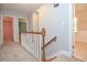 Hallway view with carpet, wooden railing, and doorways to rooms with different flooring at 4714 Marc Sw Ct, Lilburn, GA 30047