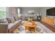 Staged living room with gray sofa, patterned rug, and modern decor provides a cozy and stylish space at 4714 Marc Sw Ct, Lilburn, GA 30047