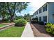 Manicured yard featuring a walkway, mature trees and bushes adjacent to the two-story home at 4714 Marc Sw Ct, Lilburn, GA 30047
