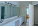 Bathroom with double sinks, large mirror, and walk-in closet access at 851 Roget Ct, Lawrenceville, GA 30045