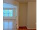 Open doorway into a light-filled living area with wood floors and large window at 851 Roget Ct, Lawrenceville, GA 30045