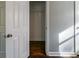 Bedroom closet with dark wood floors featuring a shelf and white trim around the door and baseboard at 1555 Rupert Rd, Decatur, GA 30032