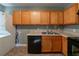 Efficient kitchen featuring wooden cabinets, black dishwasher, and tiled floor at 1555 Rupert Rd, Decatur, GA 30032