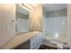Bathroom with white countertops, tub and tiled shower, framed mirror and wood look floors at 2105 Sandtree Sw Ct, Atlanta, GA 30331