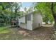 View of the home's exterior with siding, large window, and a deck in a leafy, natural setting at 2920 Cushing Ct, Jonesboro, GA 30236