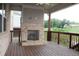 Covered back porch with a brick fireplace, wooden deck and railings, and a view of the backyard at 4933 Greenard Watson Ln, Buford, GA 30518