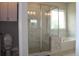 Bathroom showcasing a glass door shower, tub, tiled walls, and a window with natural light at 4933 Greenard Watson Ln, Buford, GA 30518