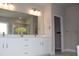 Modern bathroom features double sink with white cabinets and large vanity mirror with vanity lighting at 4933 Greenard Watson Ln, Buford, GA 30518