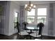Dining area with wrought iron table and chairs featuring large windows and decorative curtains for an elegant touch at 4933 Greenard Watson Ln, Buford, GA 30518
