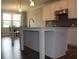 A view of the kitchen island featuring white cabinets and sink, open to the dining area in the background at 4933 Greenard Watson Ln, Buford, GA 30518