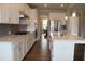 A stylish kitchen with white cabinetry, stainless appliances, a large island, and an open view to the dining area at 4933 Greenard Watson Ln, Buford, GA 30518