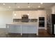 Bright kitchen featuring white cabinets, stainless steel appliances, a large island, and modern pendant lighting at 4933 Greenard Watson Ln, Buford, GA 30518