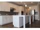 A modern kitchen with white cabinets, stainless steel appliances, grey backsplash, and a spacious kitchen island at 4933 Greenard Watson Ln, Buford, GA 30518