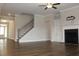 Open-concept living room with fireplace, staircase, and hardwood floors provides a modern and airy feel at 4933 Greenard Watson Ln, Buford, GA 30518
