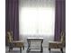 Bright sitting area features neutral walls, table, chairs, and large windows with stylish purple curtains at 4933 Greenard Watson Ln, Buford, GA 30518