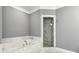 Bathroom suite with white marble tile throughout, a soaking tub, and a glass enclosed shower at 2362 Saint Davids Nw Sq, Kennesaw, GA 30152