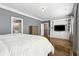 Spacious primary bedroom with en suite bathroom, hardwood floors, TV, and built in cabinet at 2362 Saint Davids Nw Sq, Kennesaw, GA 30152