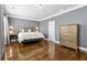 Primary bedroom with hardwood flooring, dresser, and neutral paint color at 2362 Saint Davids Nw Sq, Kennesaw, GA 30152