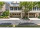 Townhome with garages, brick facade, screened porch, and mature landscaping at 2362 Saint Davids Nw Sq, Kennesaw, GA 30152