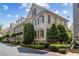 Brick townhome displaying multiple windows, mature trees, and professionally landscaped front yard at 2362 Saint Davids Nw Sq, Kennesaw, GA 30152
