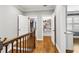 Hallway with stairs, wood railing with iron spindles, and open closet with built in shelving at 2362 Saint Davids Nw Sq, Kennesaw, GA 30152