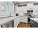 Kitchen featuring white cabinets, stainless steel appliances, and stone tile backsplash at 2362 Saint Davids Nw Sq, Kennesaw, GA 30152
