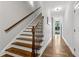 Elegant staircase with hardwood steps, detailed iron railing, and natural light from entry at 2362 Saint Davids Nw Sq, Kennesaw, GA 30152