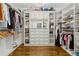 A spacious walk-in closet with custom shelves, drawers, cabinets, and beautiful hardwood floors offers ample storage at 2362 Saint Davids Nw Sq, Kennesaw, GA 30152