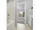 Bathroom featuring a tub, tile surround and an open view into bedroom with natural light at 2372 Johnson Rd, Atlanta, GA 30345