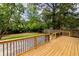 New back deck featuring modern design and dark metal railings overlooking a spacious fenced yard and lush greenery at 2736 Joyce Ave, Decatur, GA 30032