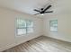 Bedroom with luxury vinyl plank flooring, modern ceiling fan, two windows, and fresh paint at 2736 Joyce Ave, Decatur, GA 30032