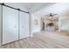 Spacious room with modern flooring, barn door access, leading to an open kitchen area at 2736 Joyce Ave, Decatur, GA 30032