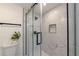 Close-up of glass-enclosed shower featuring sleek fixtures and tiled walls at 2736 Joyce Ave, Decatur, GA 30032