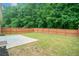 Private backyard featuring a wood fence, a small concrete patio, and lush green grass at 607 Little Shoals Ct, Canton, GA 30115