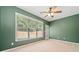 Green-walled bedroom with plush carpet, ceiling fan, and large window offering plenty of natural light at 607 Little Shoals Ct, Canton, GA 30115