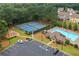 Aerial photograph displays neighborhood amenities like a tennis court, swimming pool, and playground surrounded by trees at 607 Little Shoals Ct, Canton, GA 30115