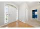 Bright foyer with hardwood floors, white trim, and a view into a hallway with carpet and blue accent wall at 607 Little Shoals Ct, Canton, GA 30115