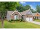 Charming home with stone accents, two car garage, bay window, and well-maintained landscaping in a lush, green setting at 607 Little Shoals Ct, Canton, GA 30115