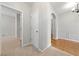 Hallway featuring neutral carpet, an archway, and views into other rooms with wood floors and neutral paint at 607 Little Shoals Ct, Canton, GA 30115