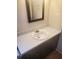 Bathroom with single sink vanity, framed mirror, and modern wood-look flooring at 204 Melanie Ln, Woodstock, GA 30188