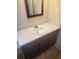Bathroom with single sink vanity, framed mirror, and modern wood-look flooring at 204 Melanie Ln, Woodstock, GA 30188