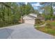The home features a spacious two-car garage and long concrete driveway lined with lush greenery at 3512 Hidden Acres Dr, Atlanta, GA 30340